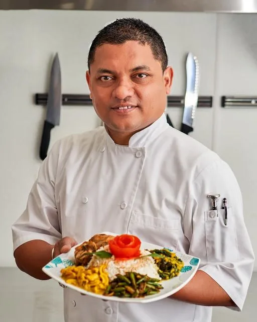 Chef Kal Peiris holding a plated Sri Lankan meal