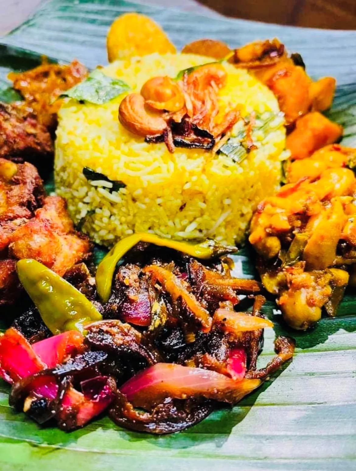 Beautiful banana leaf presentation with yellow rice and multiple curries