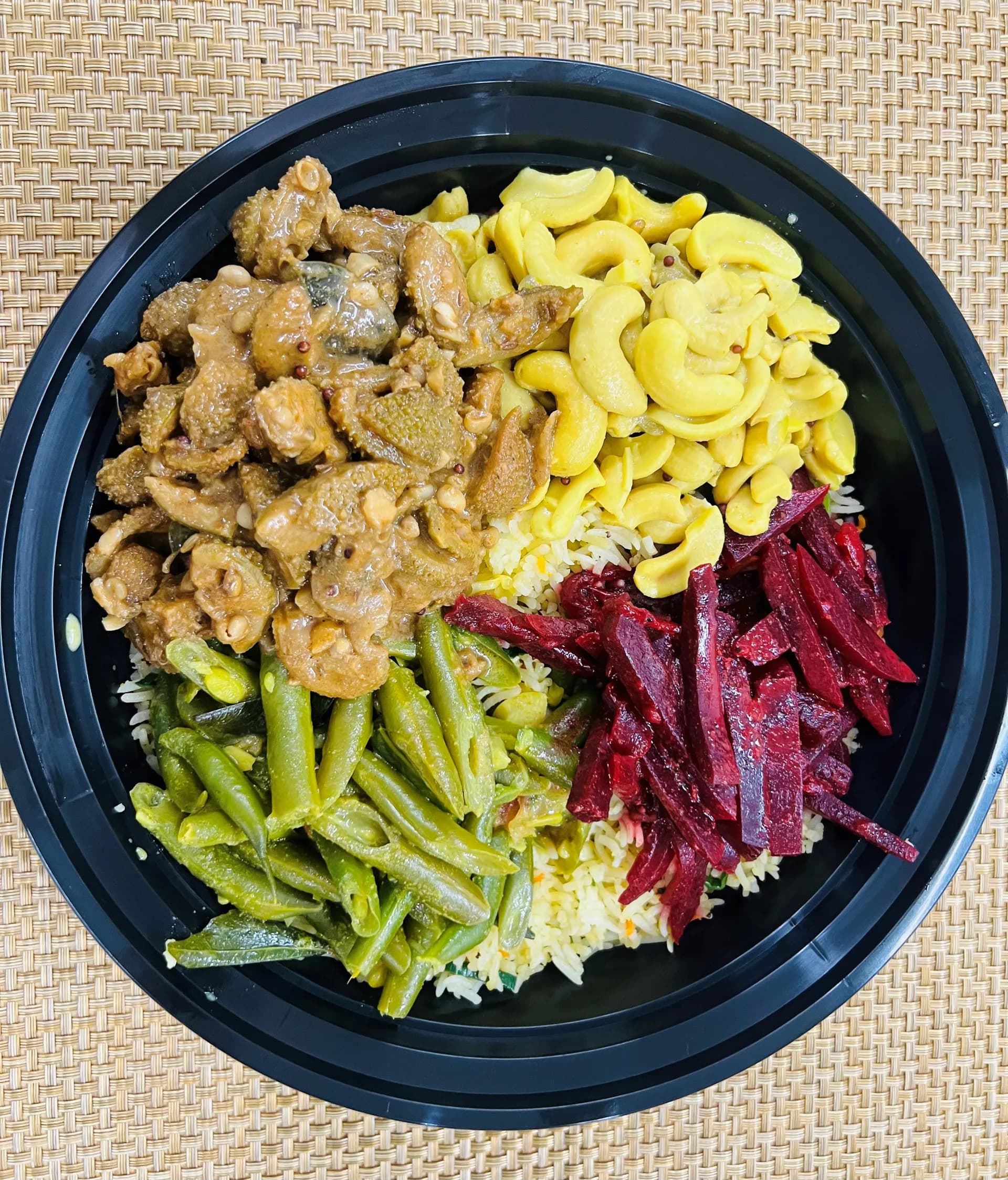 Sri Lankan rice and curry dinner box with chicken, vegetables, and sambol