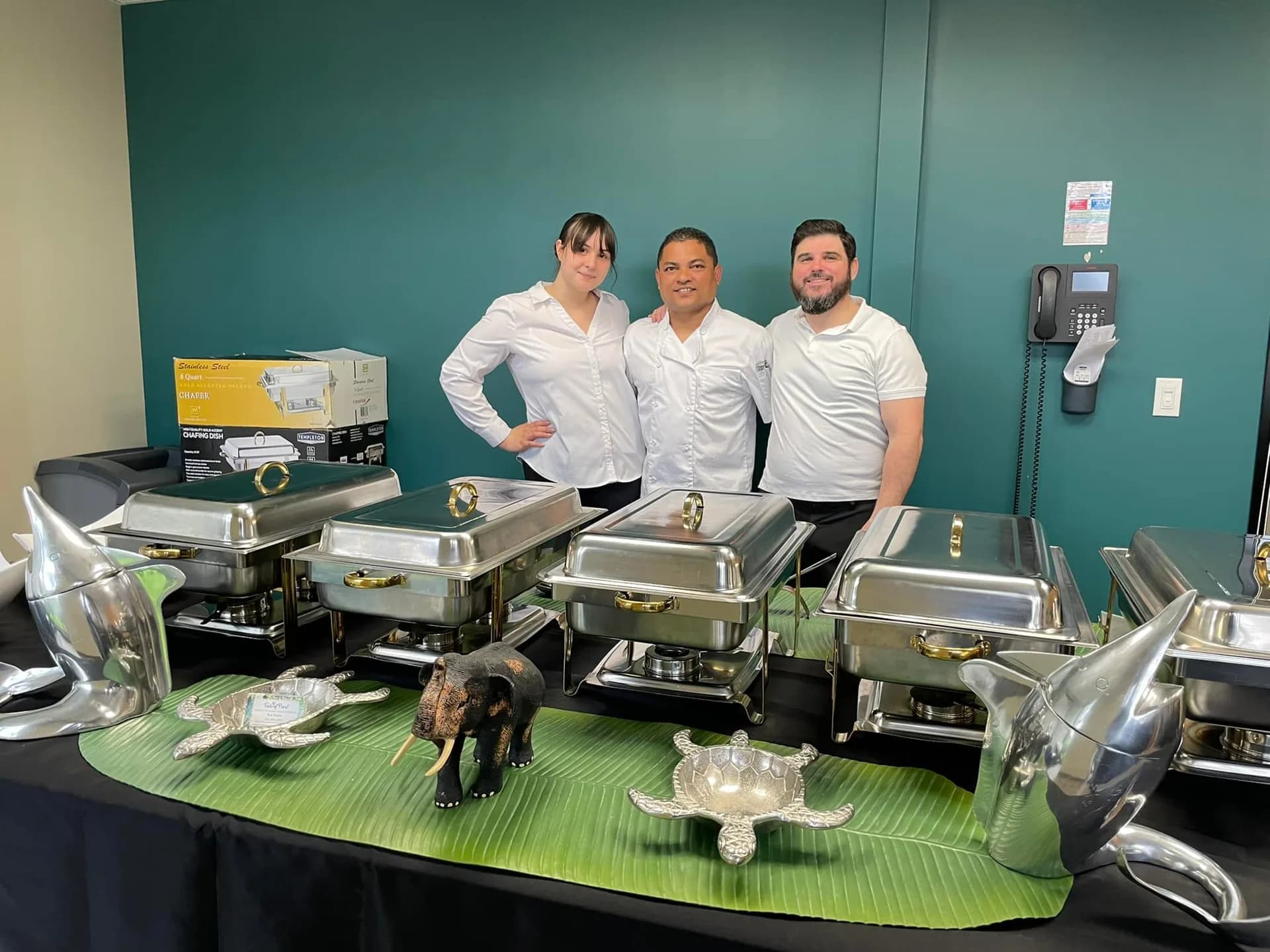 Taste of Pearl team of three behind chafing dishes with festive decorations